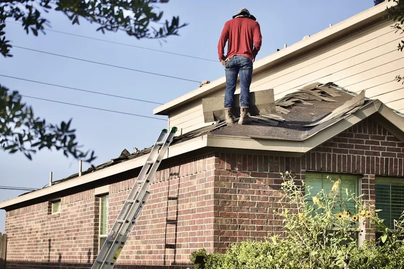 Professional roofer working on a residential roof in Pennwood Farms
